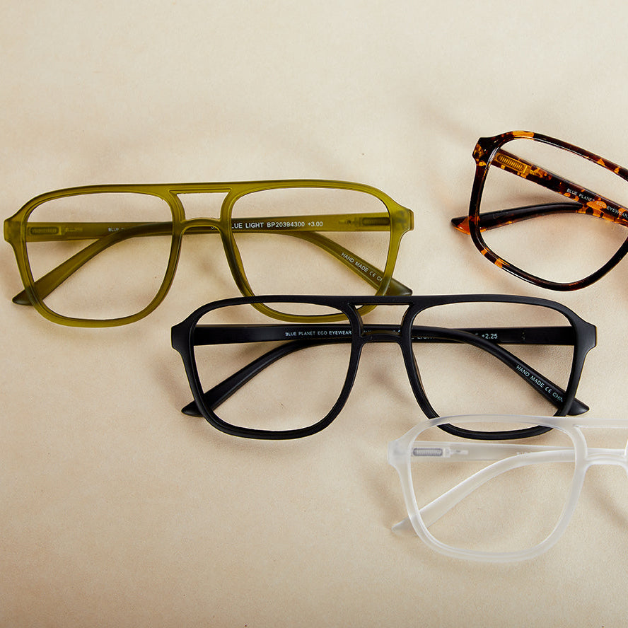 Four pairs of eyeglasses with different frames on a beige background